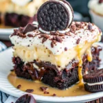 Chocolate Brownie Ice Cream Cake Recipe That Melts Hearts 7 Slice of Oreo caramel dessert with brownie base, banana layer, whipped cream, and cookie garnish