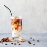 Healthy Coffee Creamer Recipes You’ll Actually Crave 6 Glass of iced coffee with cinnamon creamer, surrounded by cinnamon sticks and coffee beans